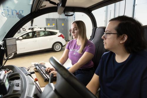 Undergraduate students work on a self-driving vehicle in ϲʷ¼'s Mobility Research Center.