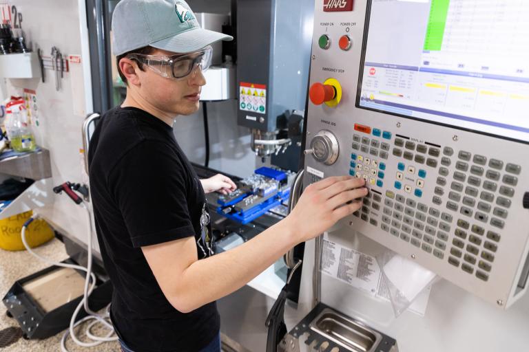 A male ϲʷ¼ student changes the settings on a machine.